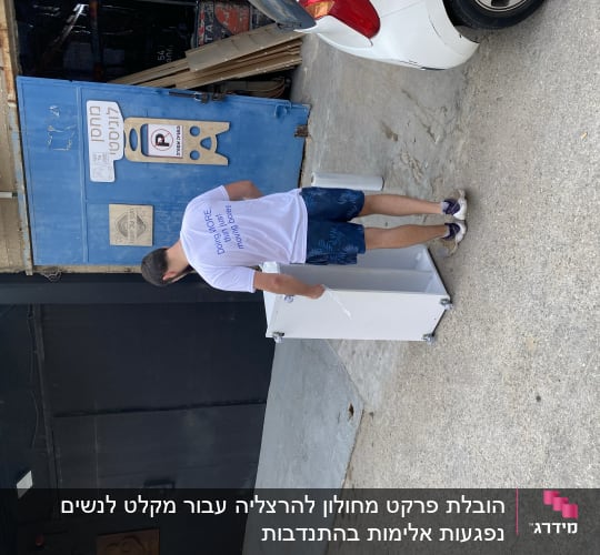 אדם מזיז ארון לבן על גלגלים בחניה